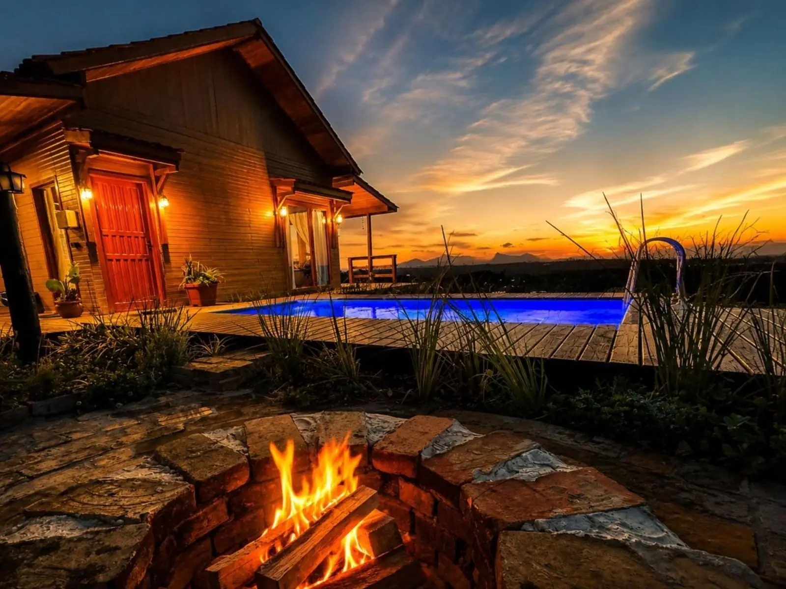 Fogo de chão e piscina iluminada ao entardecer