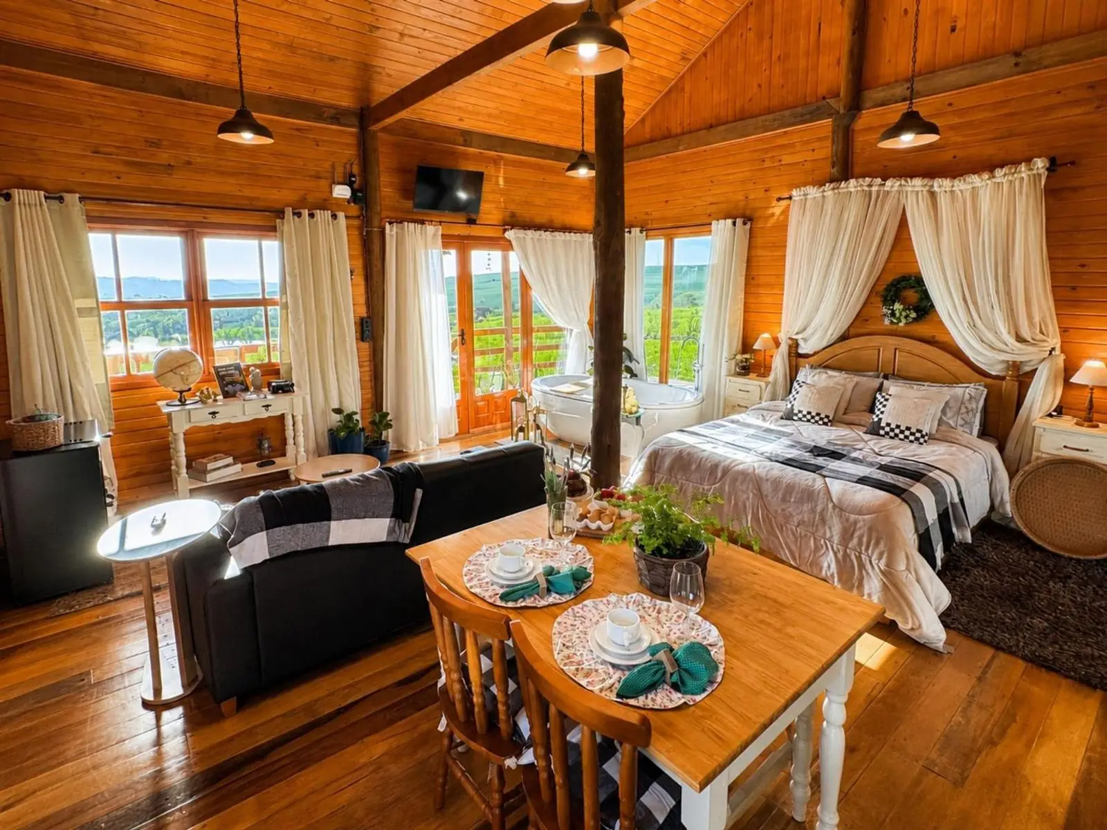 Interior com cama de dossel, mesa e sala