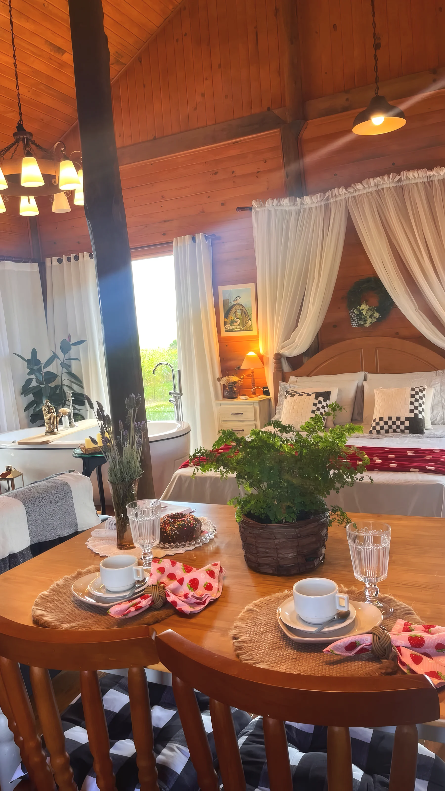 Mesa posta para o café, com a cama e a banheira ao fundo