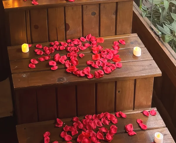 Pétalas de rosa e velas nos degraus da banheira